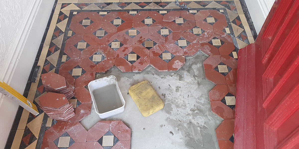 Artisan matching antique tile patterns for restoration project